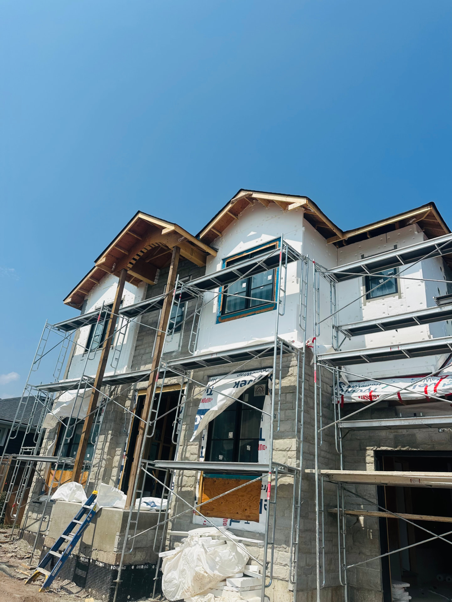 New build wrapped in foam board with scaffolding up to the gables